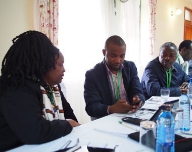 Dr Lusike Wasilwa, Director of Crop Systems, KALRO and Amos Tabalia, ACRE Africa, downloading the Telegram app and signing up to the PRISE pest forecasts.