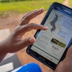 crop health advisor using a PRISE bulletin on their mobile tablet to access pest alert and advisory information